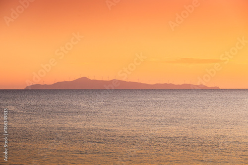 Obraz na płótnie Wind turbines sunset. Seaside landscape with a wind turbine farm on a mountain. Green energy electricity source. Concept image for eco energy. w salonie