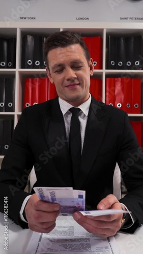 4k uhd POV handsome business man in black suit and tie counting euro with smile. The promise that the work and servise will be done. Hide money in pocket. Office indoor. Vertical Shot. photo