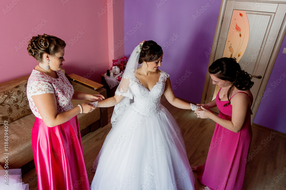 Three women are getting ready for a wedding. One of them is wearing a white dress. The other two women are helping her get ready Three women are getting ready for a wedding. One of them is wearing a white dress. The other two women are helping her get ready