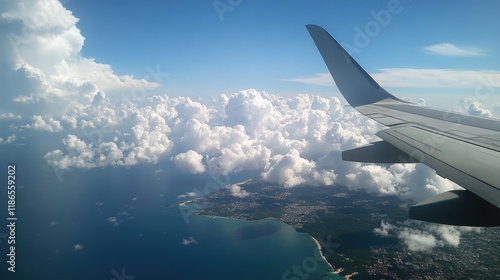 Aerial view of a vibrant blue sky and fluffy clouds from an airplane wing over a picturesque coastline and turquoise waters. photo