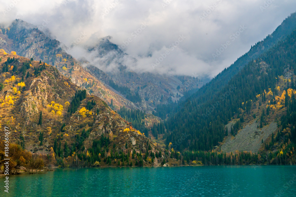 Obraz premium Foggy mountain peaks near lake Issyk, Kazakhstan during an autumn morning