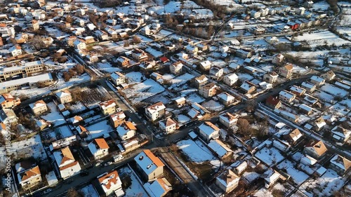 Drone view of snow covering the houses of Sapareva Banya Town on a sunny winter day in Bulgaria photo