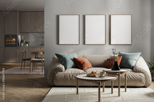 Tablou pe pânză Modern living room with a beige plush sofa, decorative pillows, nesting coffee tables, and blank frames on a neutral wall, adjacent to a minimalist kitchen