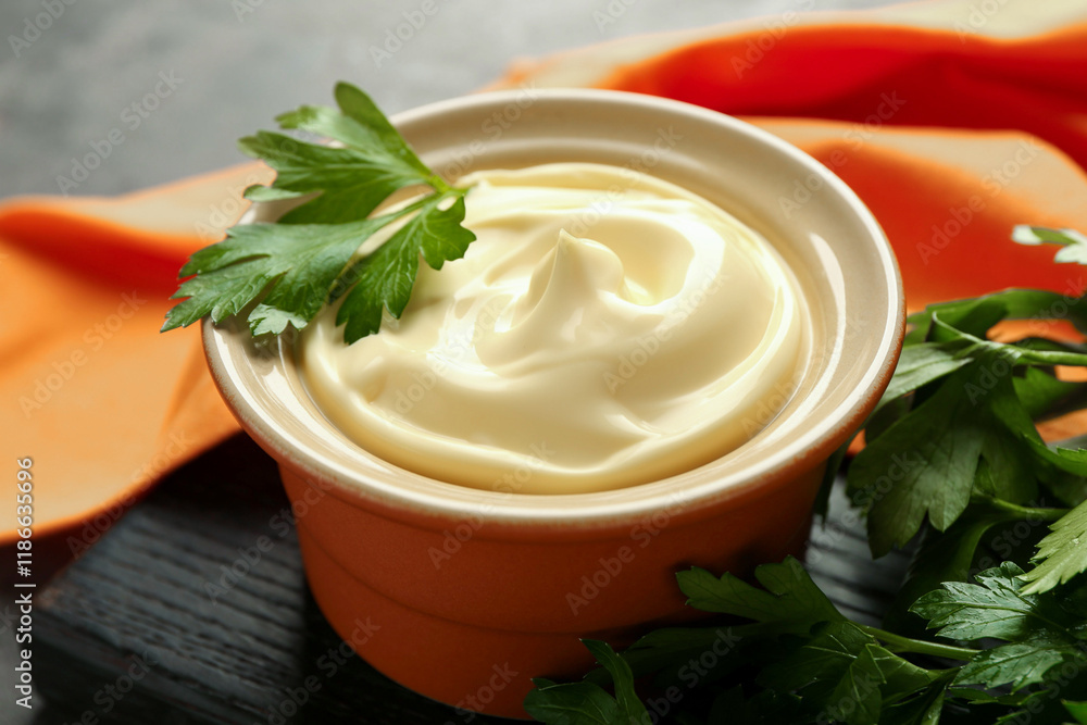 Delicious mayonnaise sauce in bowl with parsley on table, closeup Delicious mayonnaise sauce in bowl with parsley on table, closeup