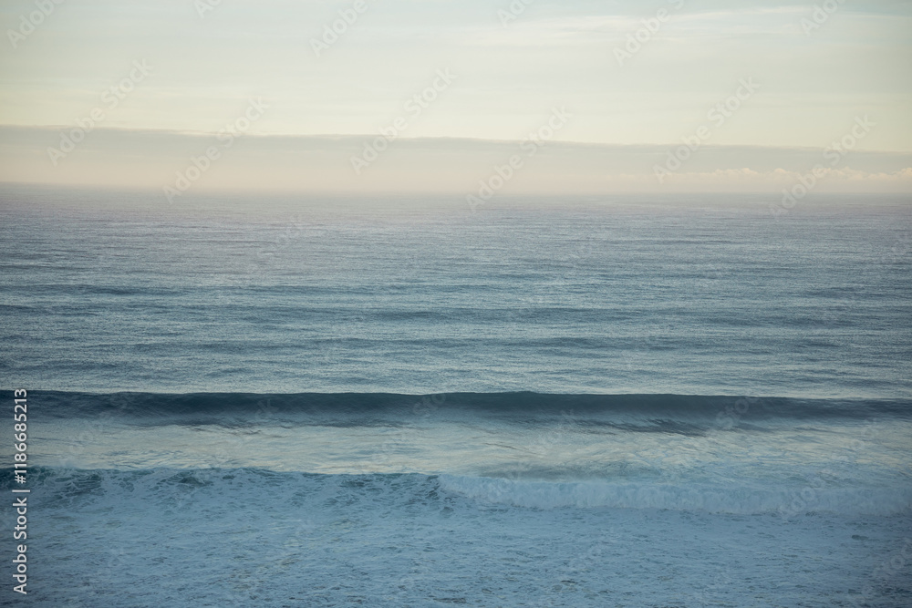 Obraz premium Sea horizon and gentle sky at sunrise with rolling waves