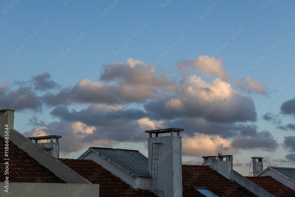 Rooftops and chimneys under a soft evening sky Rooftops and chimneys under a soft evening sky