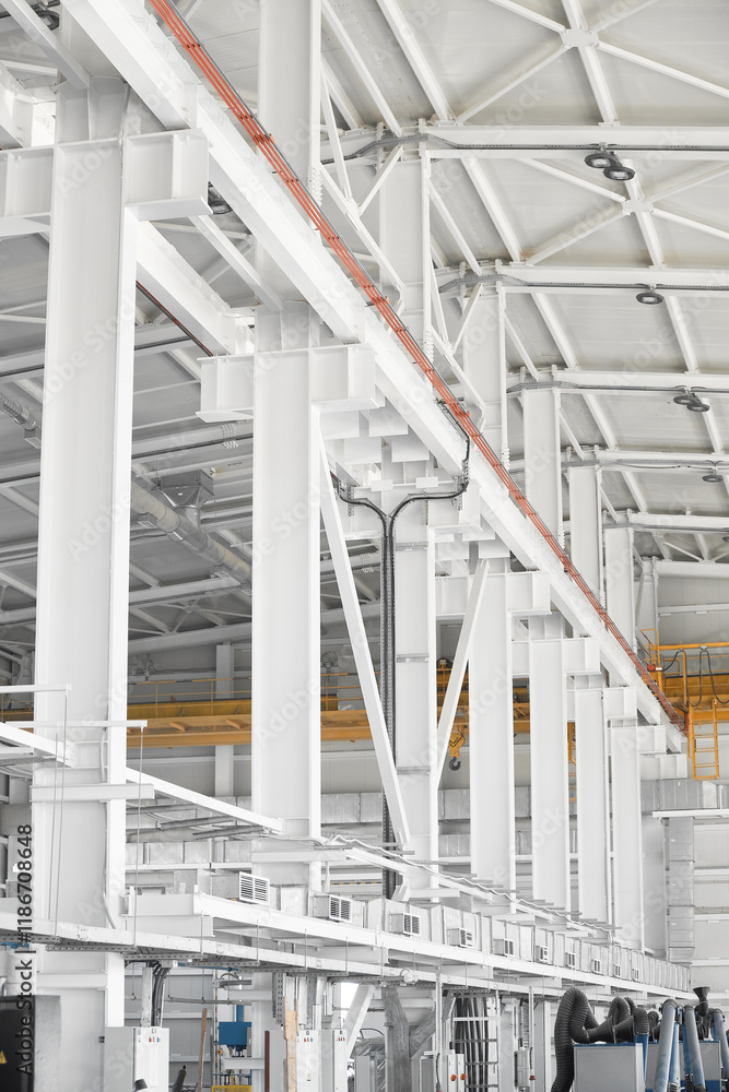 Obraz premium Overhead traveling gantry crane beam on the pillars and truss ceilings of industrial building. Crane runway girder and metal structures