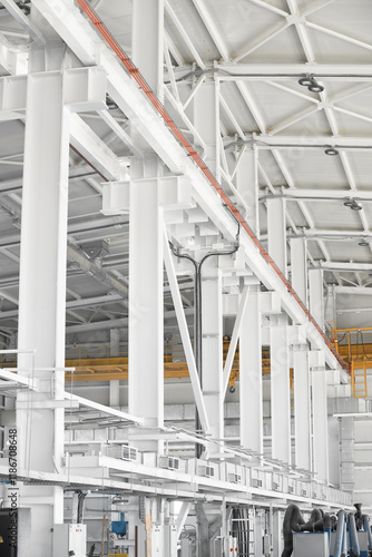 Overhead traveling gantry crane beam on the pillars and truss ceilings of industrial building. Crane runway girder and metal structures