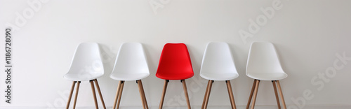 Chairs arranged in a row on a minimalist background with one red chair representing diversity and inclusion in the corporate world - a simple yet powerful design composition