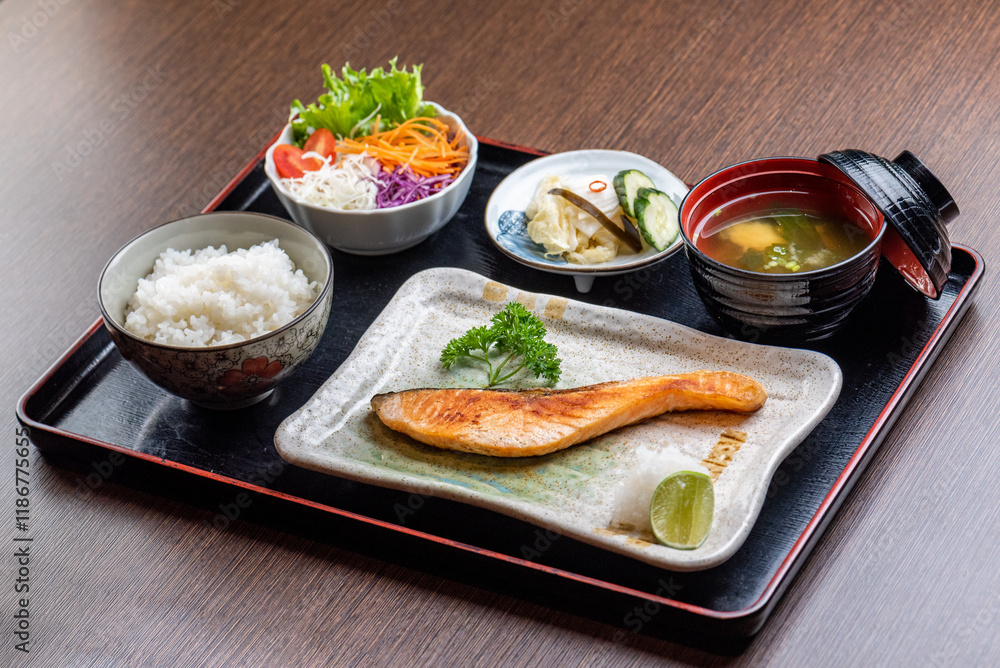 A delicious and healthy Japanese meal with grilled salmon, rice, salad, and miso soup. A delicious and healthy Japanese meal with grilled salmon, rice, salad, and miso soup.