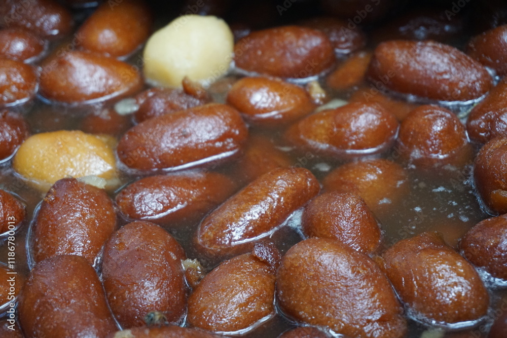 Popular Bangladeshi dessert Gulab Jamun with sugar syrup, Traditional Bangladeshi sweet called rasgulla or rasgoola is being sold at a market, Gulab jamun and rasgulla are displayed together Popular Bangladeshi dessert Gulab Jamun with sugar syrup, Traditional Bangladeshi sweet called rasgulla or rasgoola is being sold at a market, Gulab jamun and rasgulla are displayed together