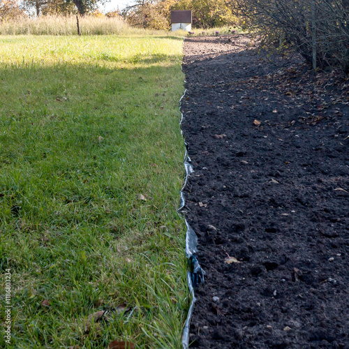 Contrast of Green Lawn and Prepared Soil in Garden Scene photo