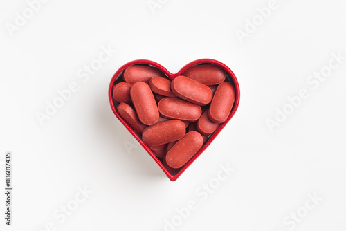 Obraz na płótnie The heart made of red pills on a white background