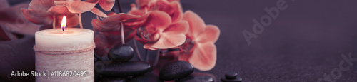 Spa background with pink orchid , candle and zen black stones .