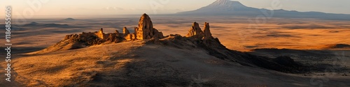 Aerial panorama of the Shira Cathedral rock formation glowing under golden hour light, with Mount Kilimanjaros summit in the distance, in 4K resolution photo