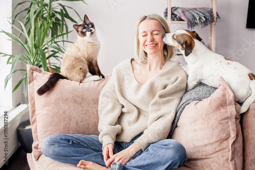 Happy woman playing with her dog on the couch at home
