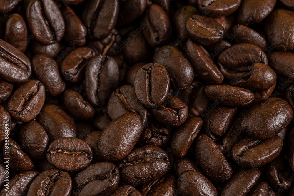 Fototapeta premium Aromatic Roasted Coffee Beans Textured Background. Close-up of roasted coffee beans forming a textured background. Perfect for concepts related to coffee production, brewing, café culture