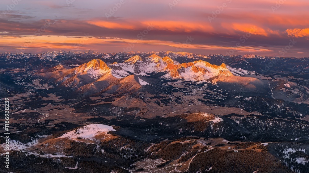 Fototapeta premium Sunset over snow-capped mountains, aerial view.
