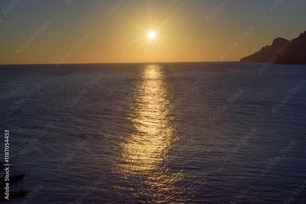 Sol poniéndose en el horizonte mediterranoe y reflejos en el mar Sol poniéndose en el horizonte mediterranoe y reflejos en el mar