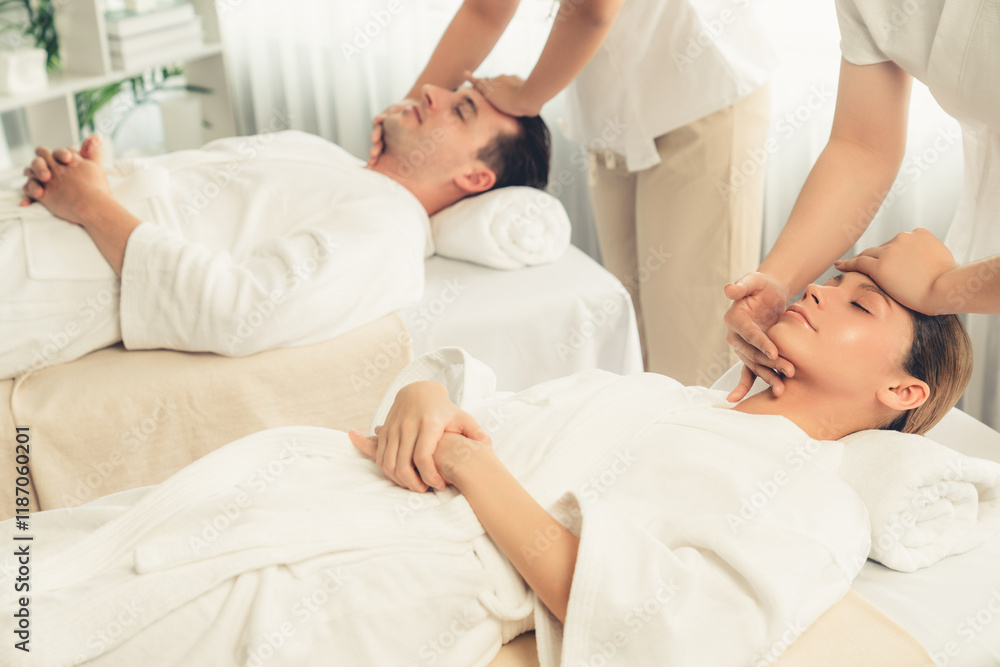 Obraz premium Caucasian couple enjoying relaxing anti-stress head massage and pampering facial beauty skin recreation leisure in dayspa modern light ambient at luxury resort or hotel spa salon. Quiescent
