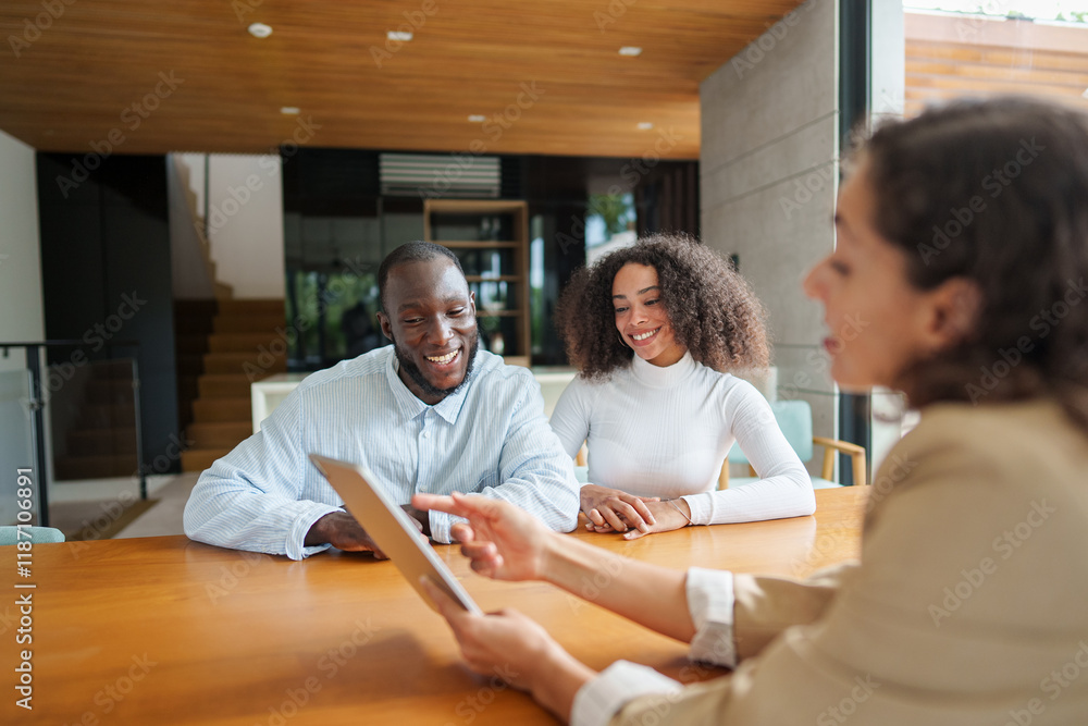 Obraz premium Professional real estate agent in business attire discusses property details with diverse couple at modern office. Digital tablet enhances interactive consultation in contemporary workspace.