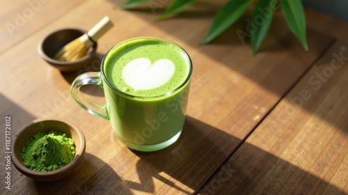 Aromatic Green Tea Latte with Heart Design in Glass Mug on Wooden Table