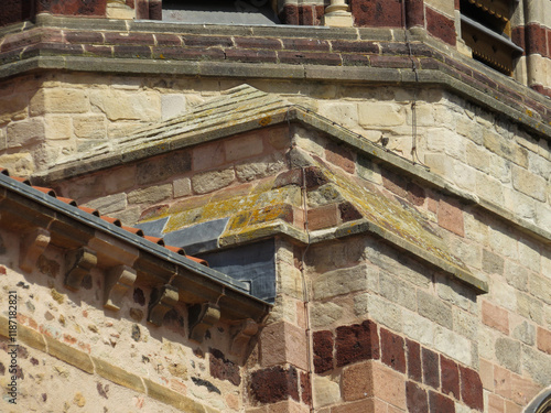 Romanesque Basilica of Saint Julian of Briuode. France.
Detail of buttress with ashlars in colorful stones.  photo