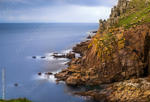 Ocean waves crash on rugged cliffs.