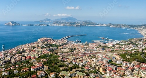Aerial view of Pozzuoli, a town of the Metropolitan City of Naples, in Campania, Italy. It's the main city of the Phlegrean Peninsula. In background are Miseno Cape and Ischia and Procida islands.