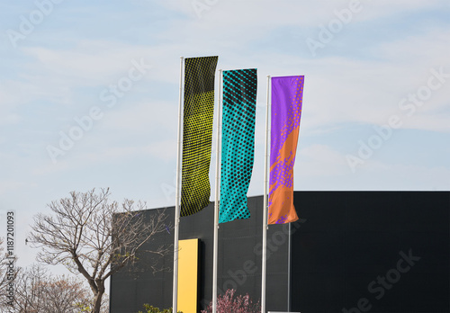 Customizable Mockup of Three Blank fly banner Flags Against a Modern Building Backdrop