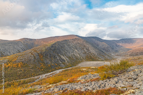 View to Mannepakhp river valley at Khibiny mountains. Stones and small trees. Early autumn in arctic tundra region. Kola peninsula, Murmansk region, Russia. photo