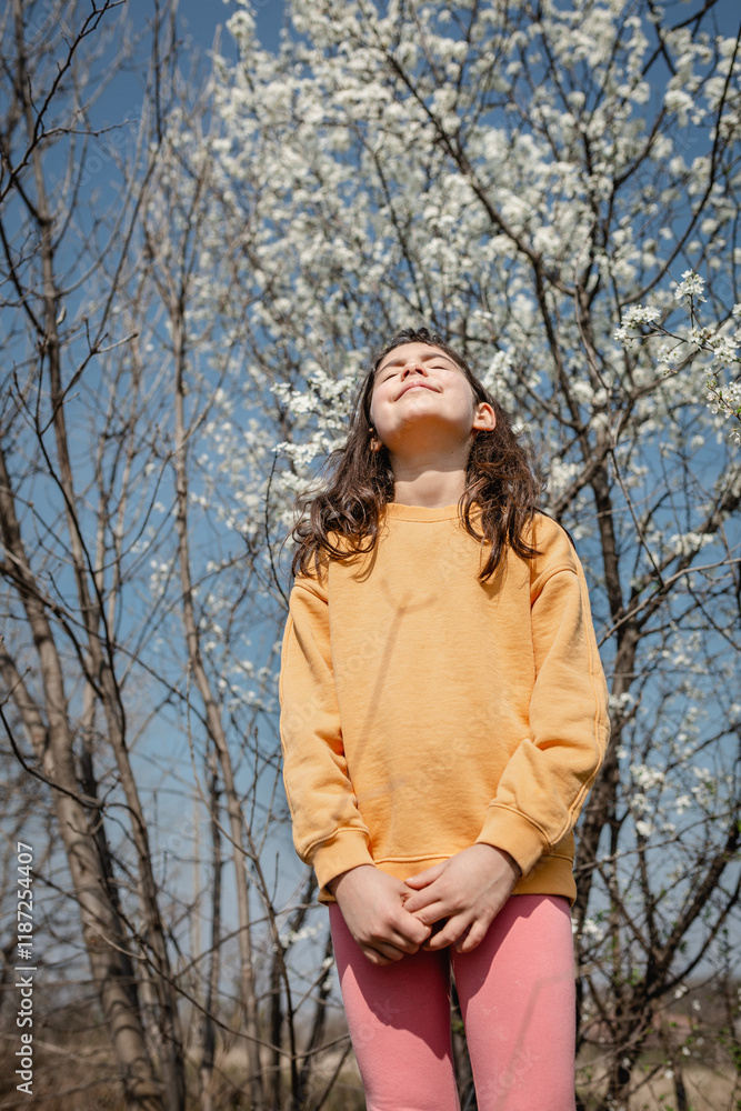 low angle view of standing girl against sky and blooming trees low angle view of standing girl against sky and blooming trees