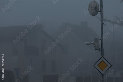 In a bustling urban environment, thick fog obscures various buildings and street signs, creating a mysterious and atmospheric scene photo