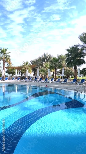 Wallpaper Mural Poolside retreat surrounded by blue loungers, tranquil palm trees, sparkling water reflecting sunlight, creating poolside haven for unwinding and enjoying peaceful retreat in refreshing outdoor vibes Torontodigital.ca