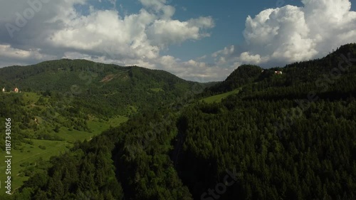 Pull-back aerial view of the dense forests near the mountainside village of Paraul Rece, Romania photo