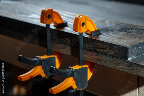 Cuadro en lienzo Carpenter two clamps are fixed to boards, closeup