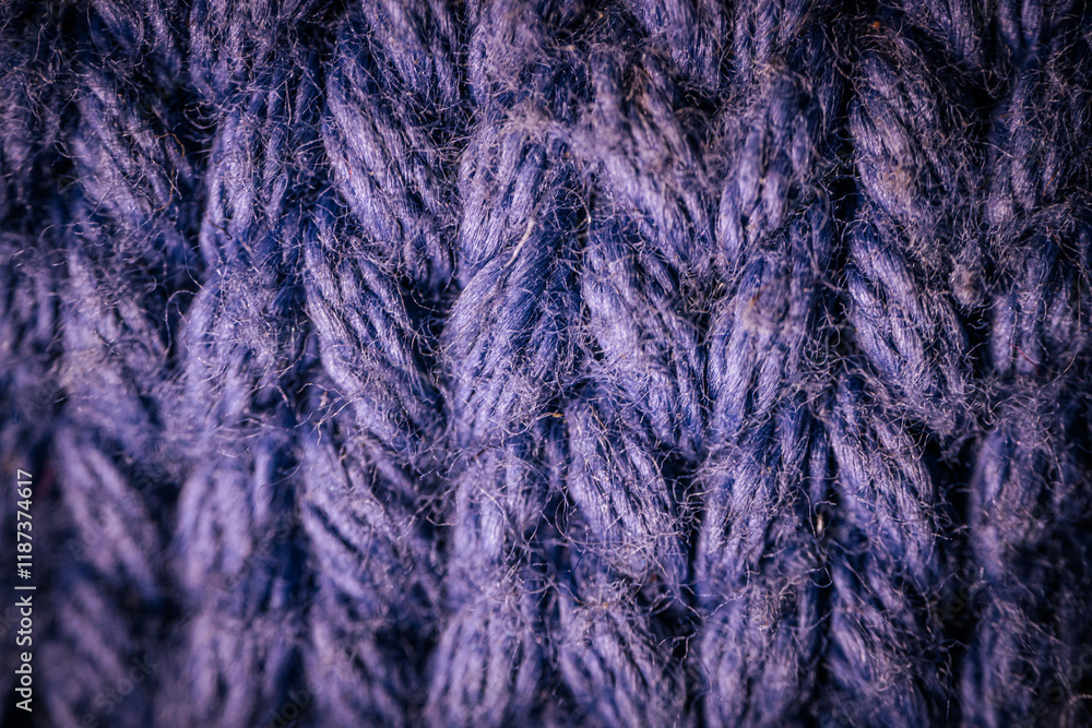 A macro view of dark blue knitted fabric showcasing the rich texture and thick yarn weave. The soft and intricate fibers highlight the cozy and durable material. A macro view of dark blue knitted fabric showcasing the rich texture and thick yarn weave. The soft and intricate fibers highlight the cozy and durable material.