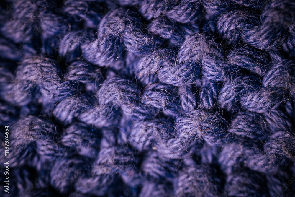 A macro view of dark blue knitted fabric showcasing the rich texture and thick yarn weave. The soft and intricate fibers highlight the cozy and durable material. A macro view of dark blue knitted fabric showcasing the rich texture and thick yarn weave. The soft and intricate fibers highlight the cozy and durable material.