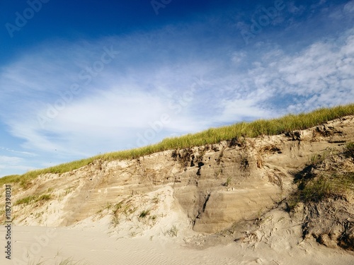 Steile, hohe Abbruchkante einer Düne an einem Strand mit starken Strumfluten photo