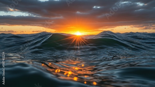 Fototapeta Naklejka Na Ścianę i Meble -  Ocean sunset with wavy surface, light rays, and a cloudy sky.