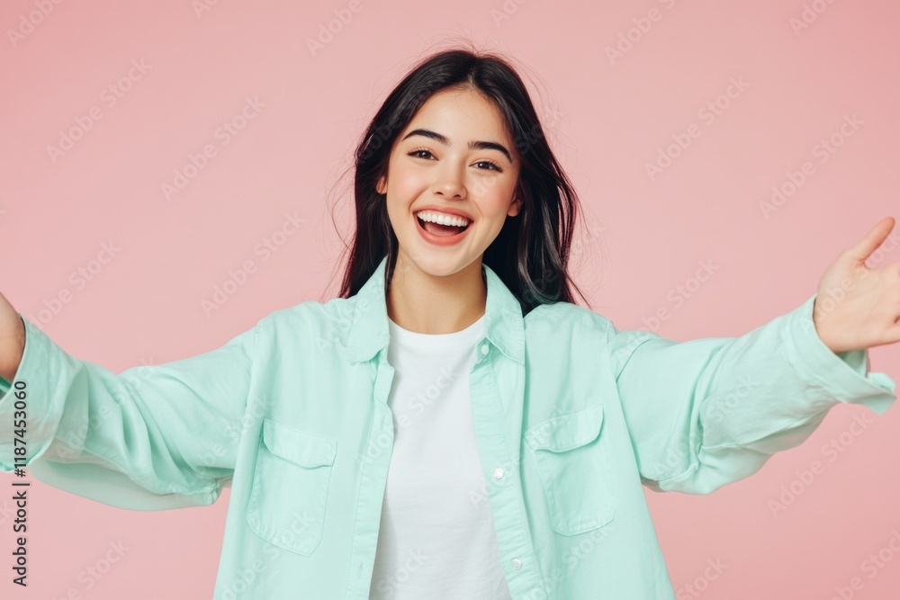 Fototapeta premium A woman wearing a green shirt holds her arms open, ready to receive something