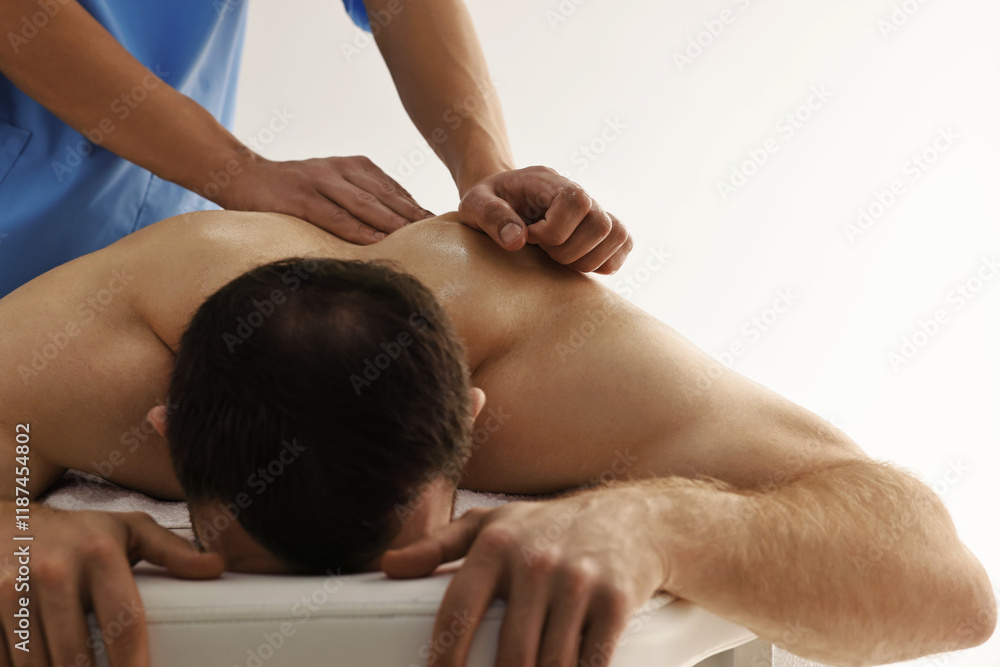Fototapeta premium Professional physiotherapist doing back massage for his client indoors, closeup