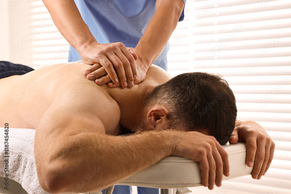 Fototapeta premium Professional physiotherapist doing neck massage for his client indoors, closeup