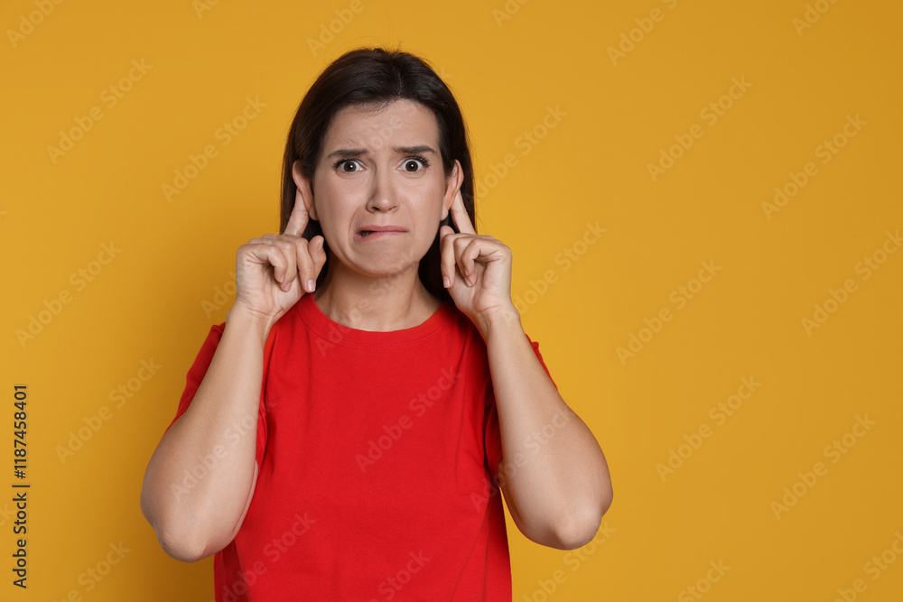 Woman showing hand to ear gesture on orange background, space for text Woman showing hand to ear gesture on orange background, space for text