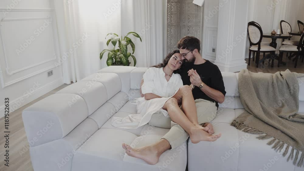 A couple sits comfortably on a stylish sofa in a modern living room, creating a warm atmosphere A couple sits comfortably on a stylish sofa in a modern living room, creating a warm atmosphere