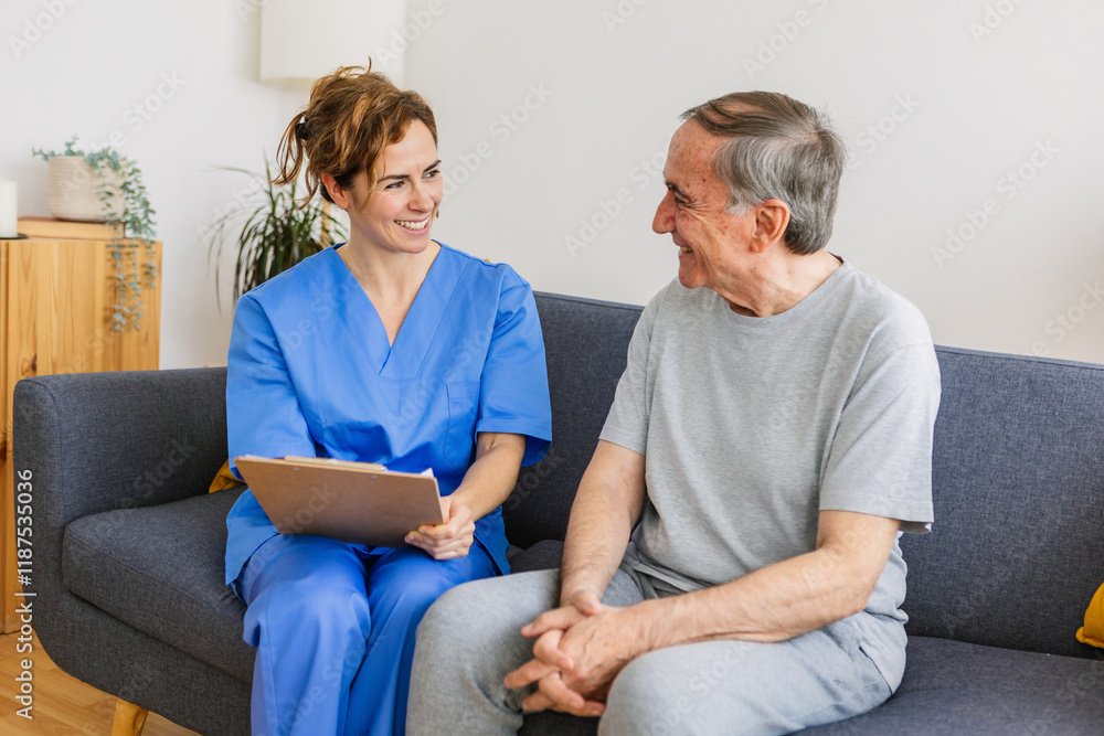 Obraz premium Young female general practitioner in blue uniform talking with aged senior patient during checkup at home.
