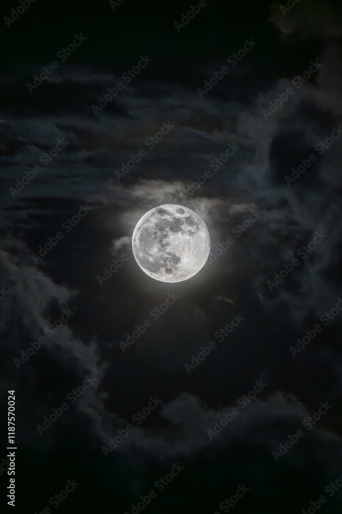 Fototapeta premium Hermosa luna llena, rodeada de nubes durante una noche obscura