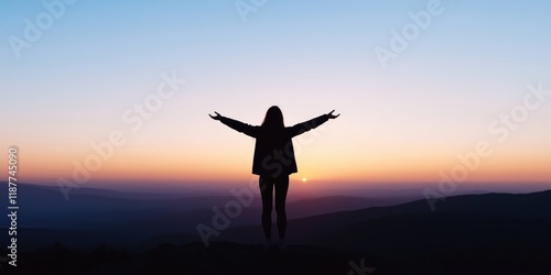 Wallpaper Mural A serene silhouette of a person standing with outstretched arms, embracing the sunset on a hilltop, representing freedom, joy, and the beauty of nature's daily gifts. Torontodigital.ca