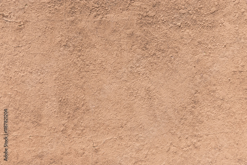 Earthy orange brown and yellow toned cracked grunge wall background texture for textured stone backdrop for ad space or copy space