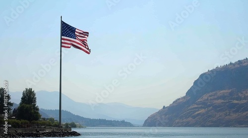 American flag waving by a lake with mountains in the background.